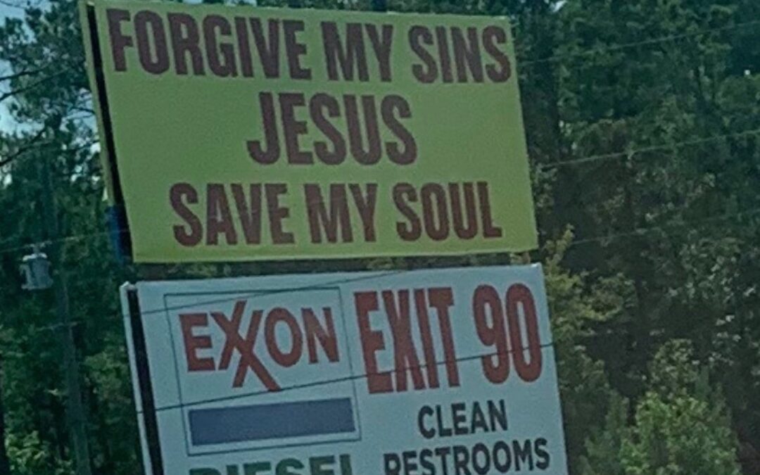 A yellow billboard on a roadside that says in red letters, “Forgive my sins Jesus. Save my soul.”