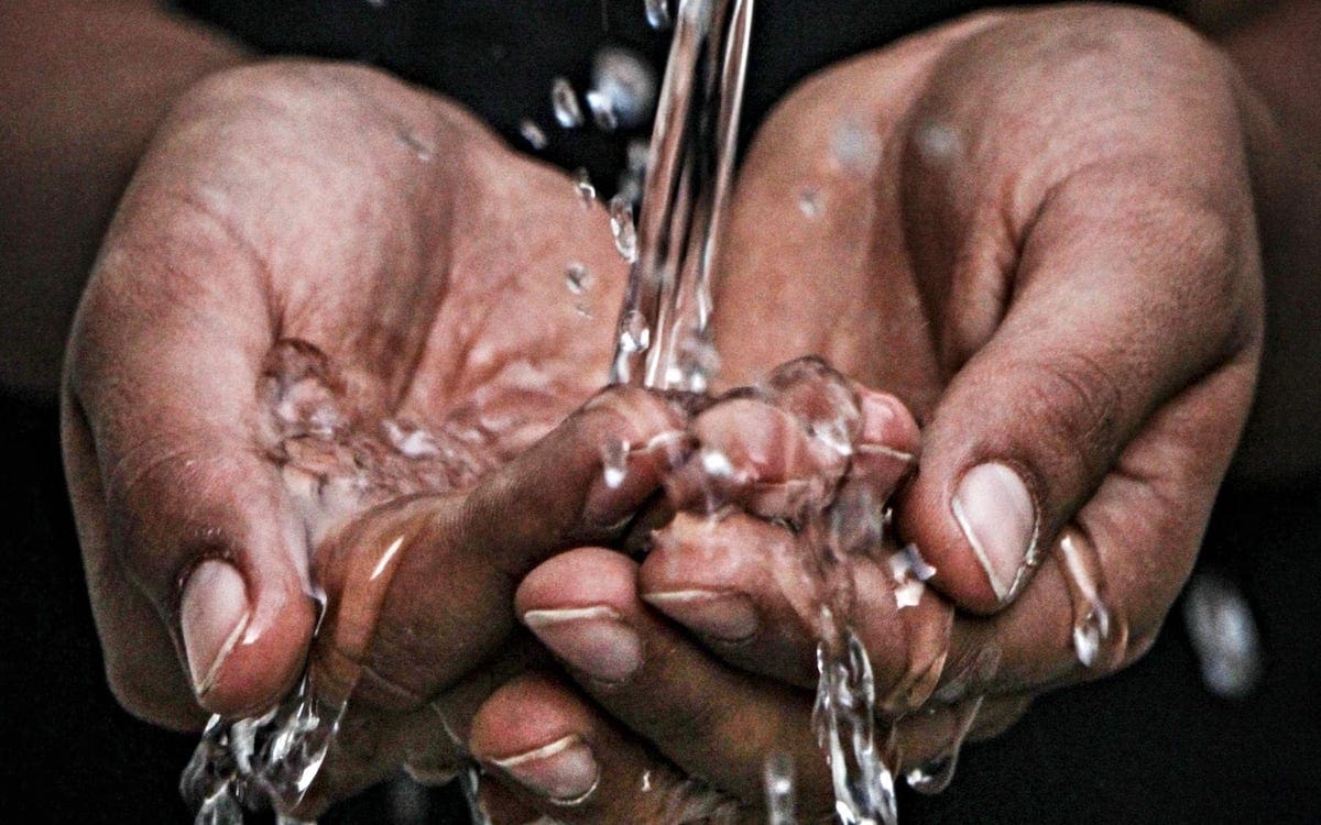 Water flowing over hands while washing.