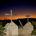 Sunrise illuminates crosses atop grave markers.