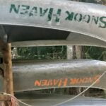 Several aluminum canoes sitting upside down on a storage rack.