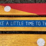 A wooden bench with the words, “Take a little time to think,” on it.
