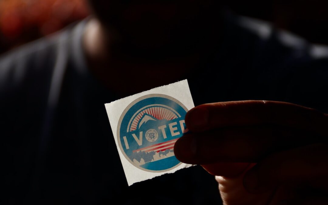 A person holding an “I Voted Sticker.”