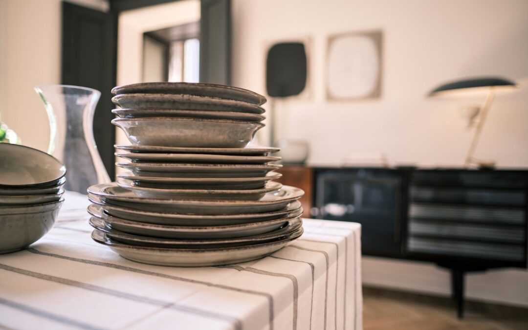 A stack of plates and bowls on a countertop in a kitchen.