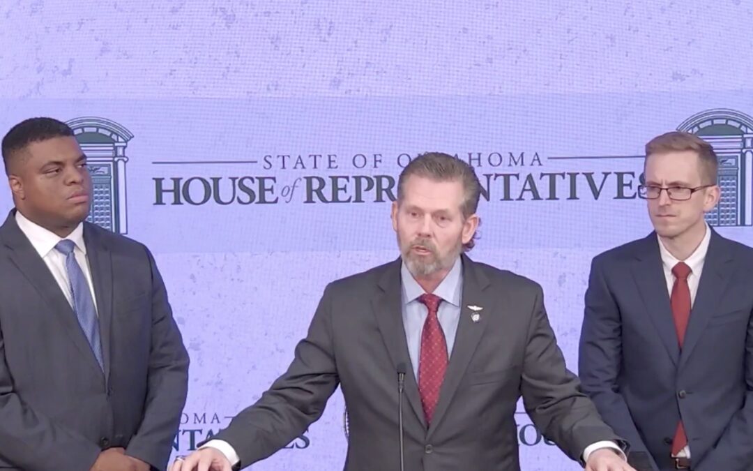 Three men standing next to each other during a press conference.