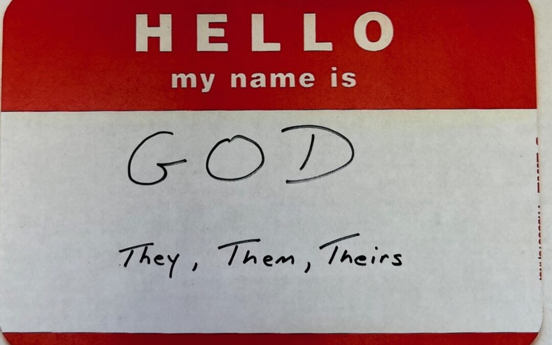 A red and white name tag with “God. They, Them, Theirs.” Written on it.