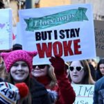 A sign held up during a march that says, “I love naps, but I stay woke.”