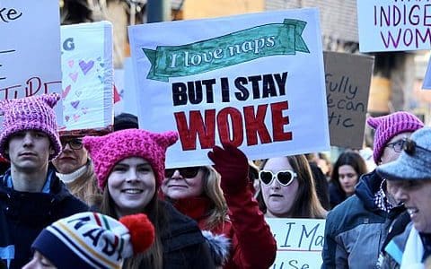 A sign held up during a march that says, “I love naps, but I stay woke.”