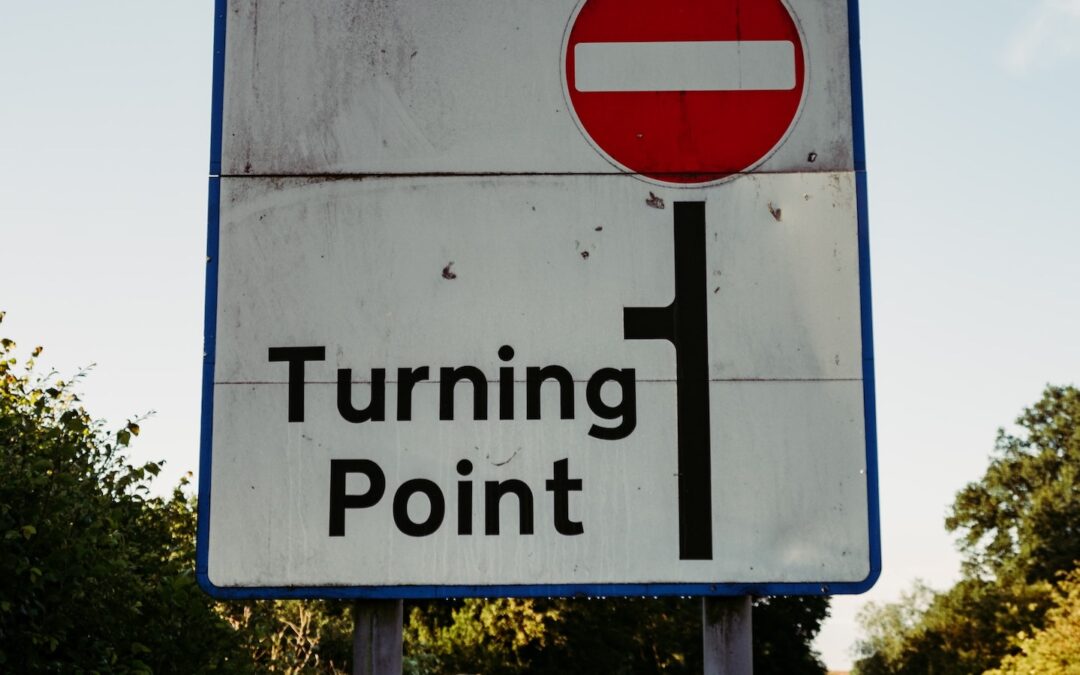 A red and white road sign that says, “Turning Point.”