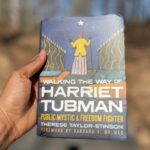 A person holding a copy of Therese Taylor-Stinson’s book 'Walking the Way of Harriet Tubman: Public Mystic and Freedom Fighter.'