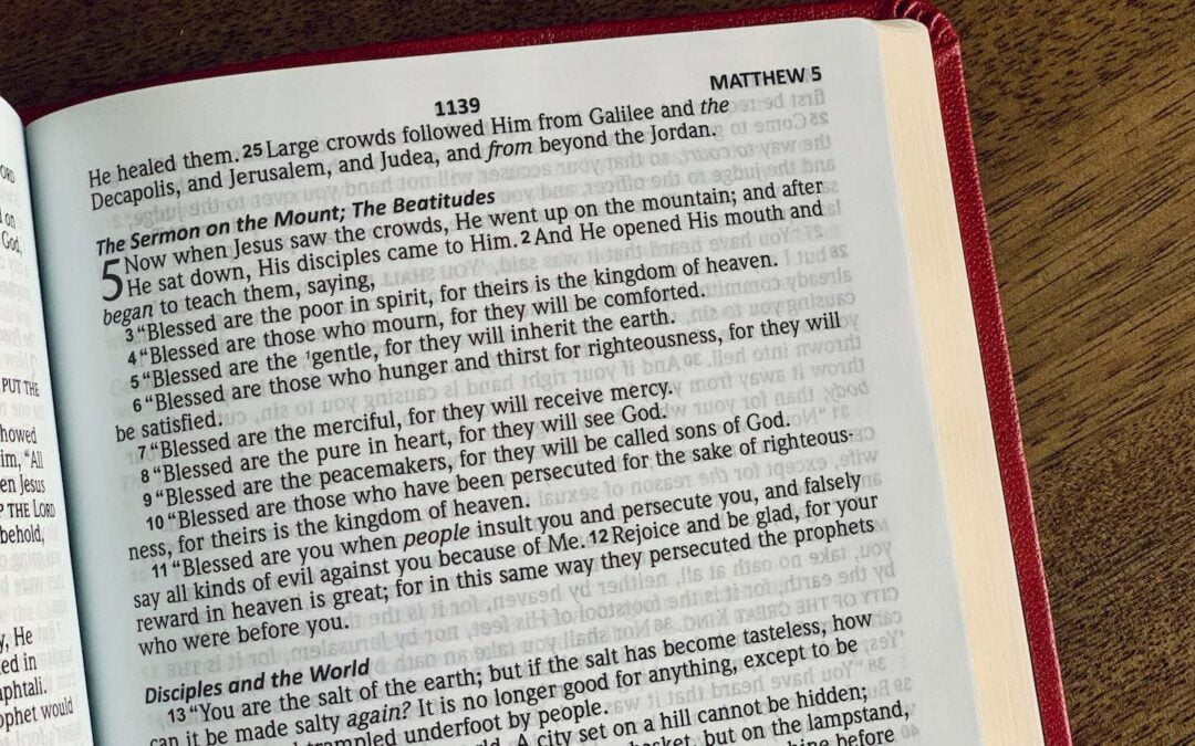 A Bible open to Matthew 5 sitting on a table.