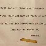 A paper sign posted on a wall giving instructions about what to do with garbage and recycling.