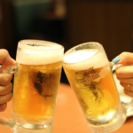 Two people toasting with mugs of beer