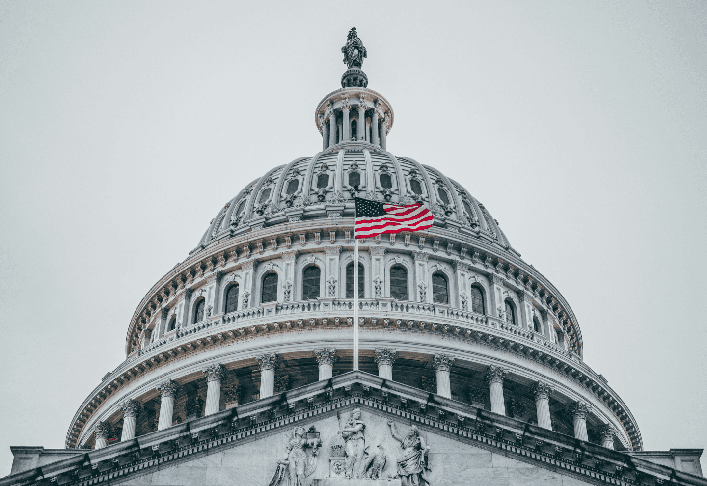 Close up of the United States Capitol in Washington D.C. with an American flag waving.