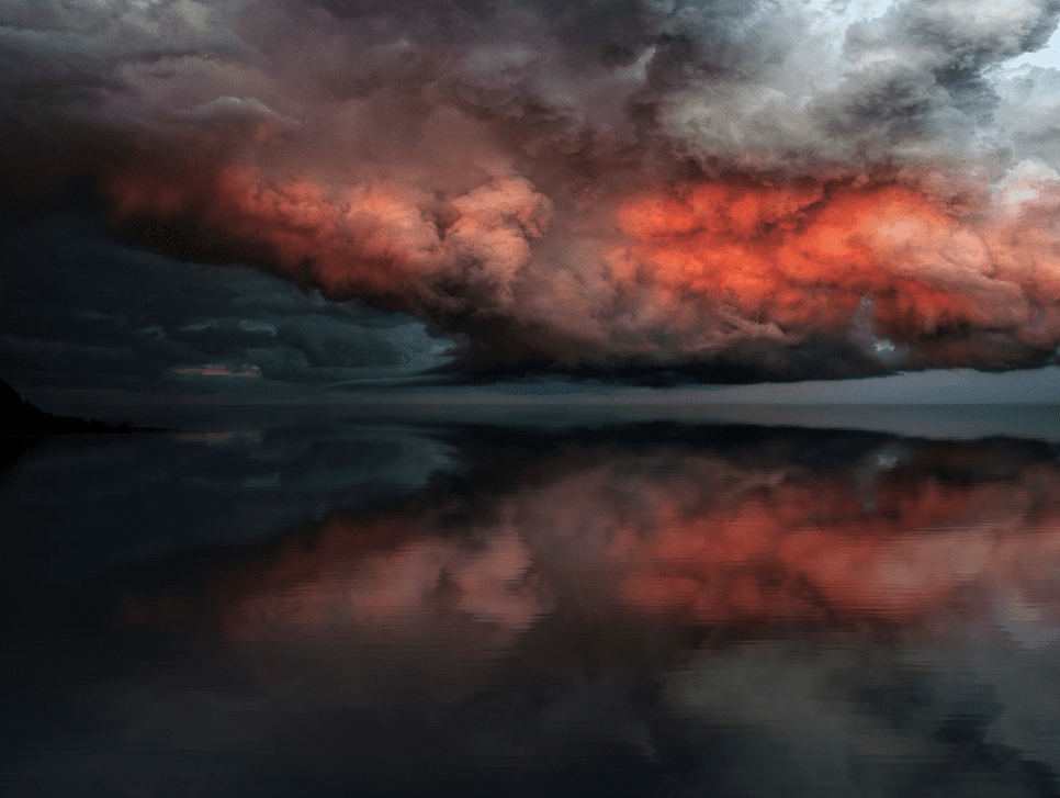 Storm clouds converging over water.