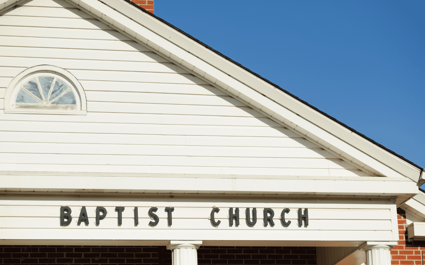 The front of a church with the words “Baptist Church” isolated.