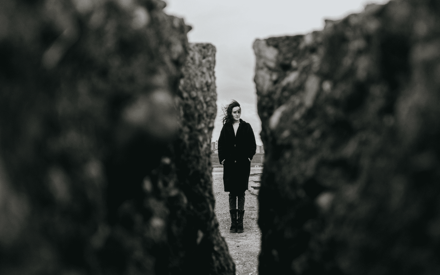 A woman prepared to walk into a narrow gap between two stones.