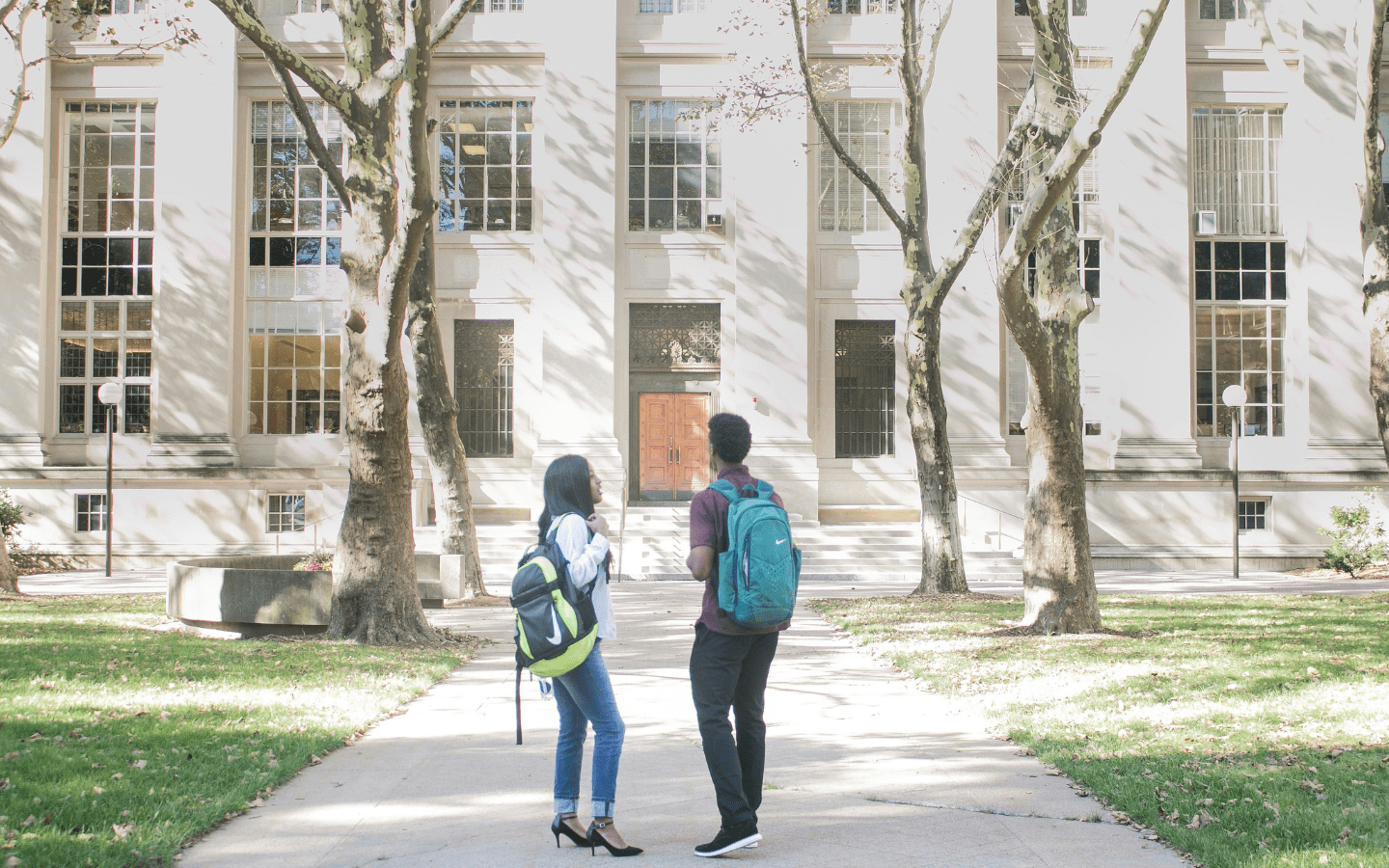 A photo of two college students standing in front of an academic building.|A table at Baylor’s church fair set up with information about a church