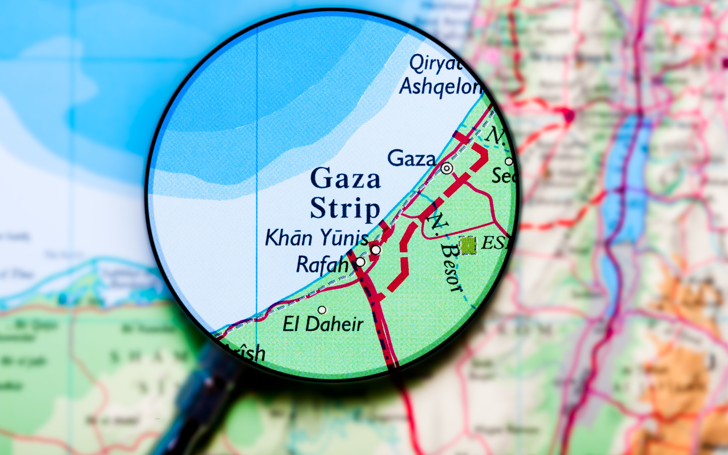 A magnifying glass hovered over the Gaza strip on a map.