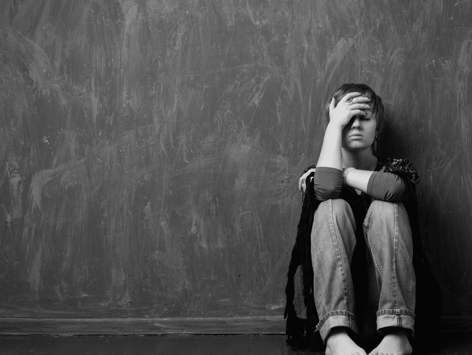 A black and white photo of a woman appearing sad
