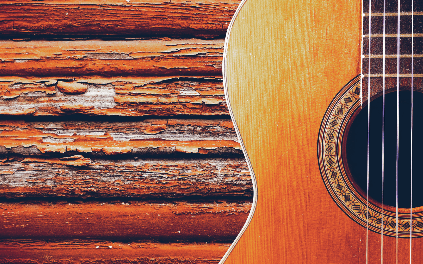 A guitar laying on a chipped-wood surface.