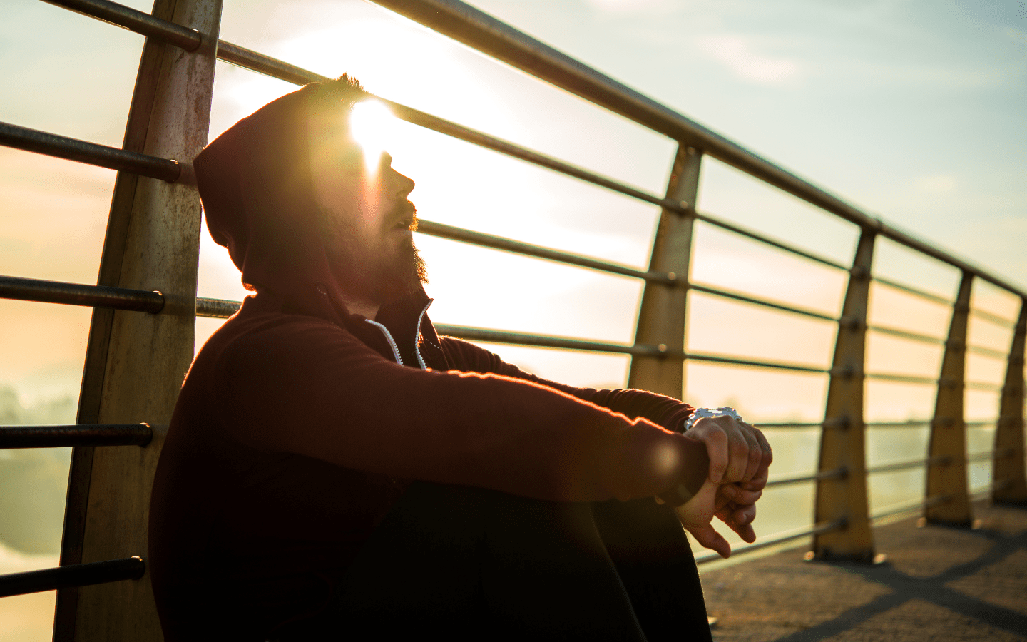 A man recovering from a run on a bridge.
