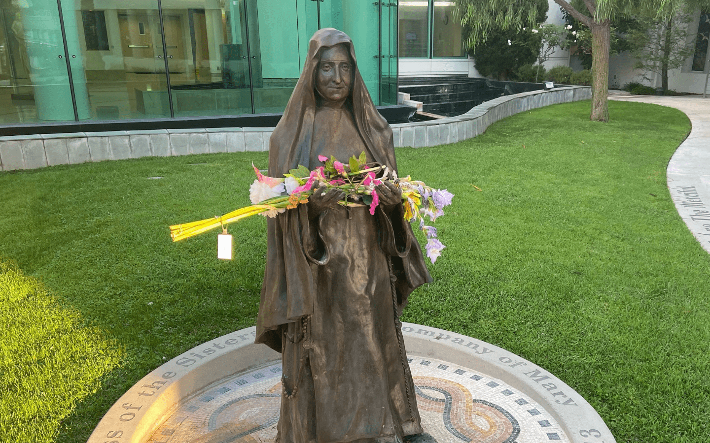 A statue of Mary Potter with flowers placed in her hands.