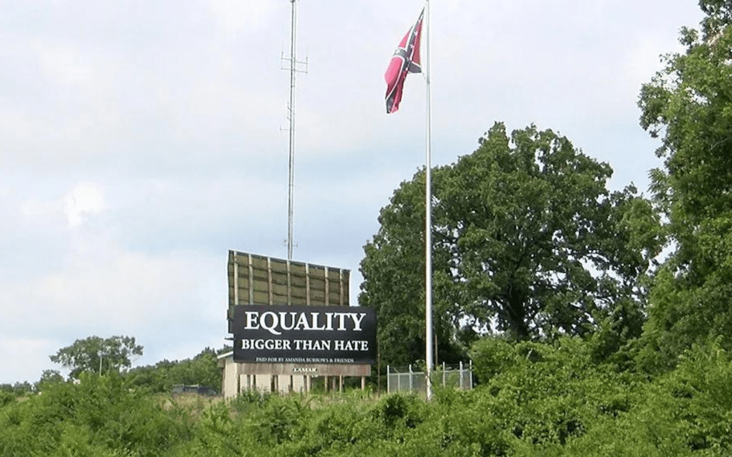 A sign along the highway in Missouri that reads “Equality: Bigger than Hate” placed next to a Confederate Flag.