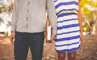 A man and a woman holding hands and a Bible.