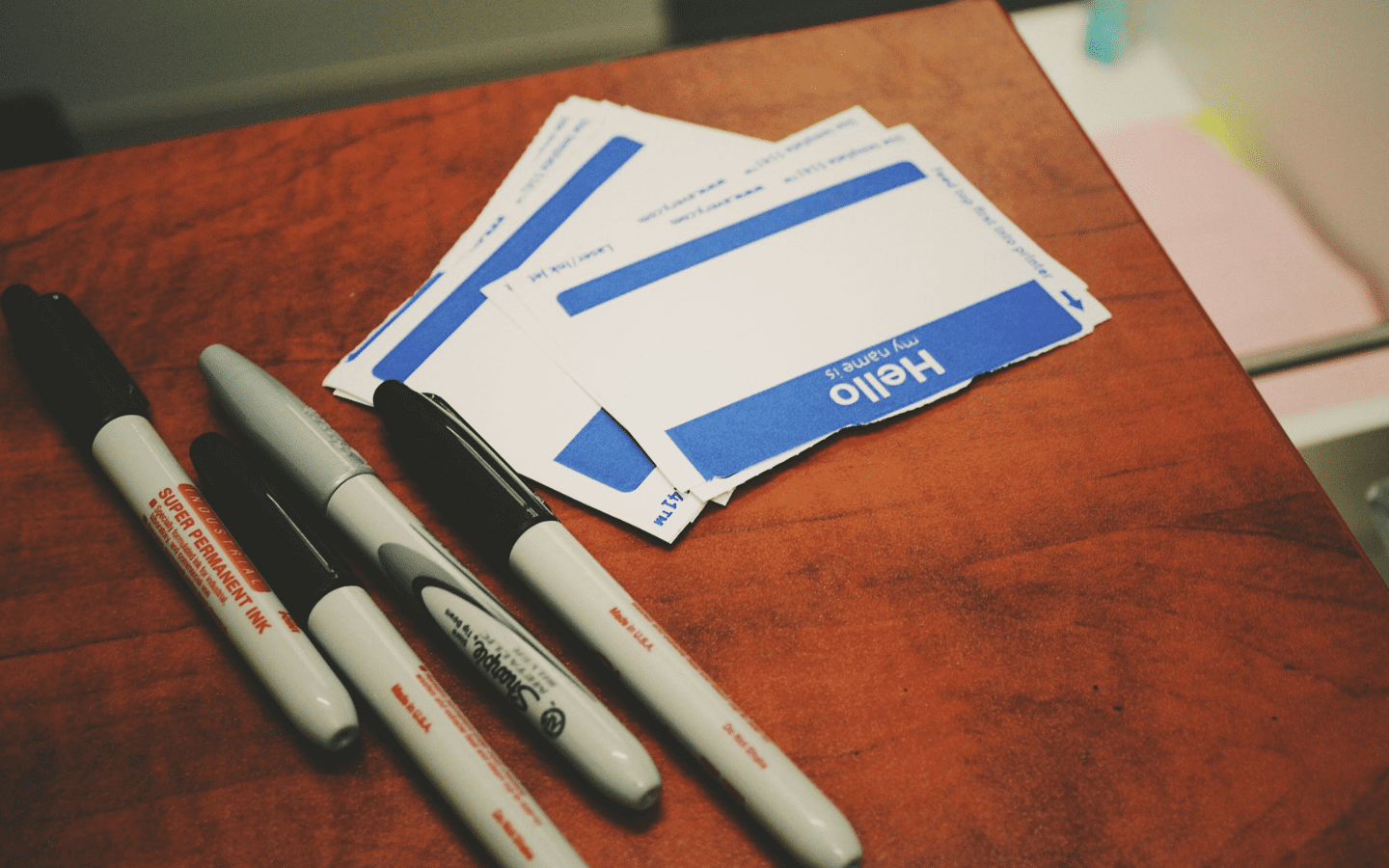 A photo of name tag stickers alongside Sharpies.