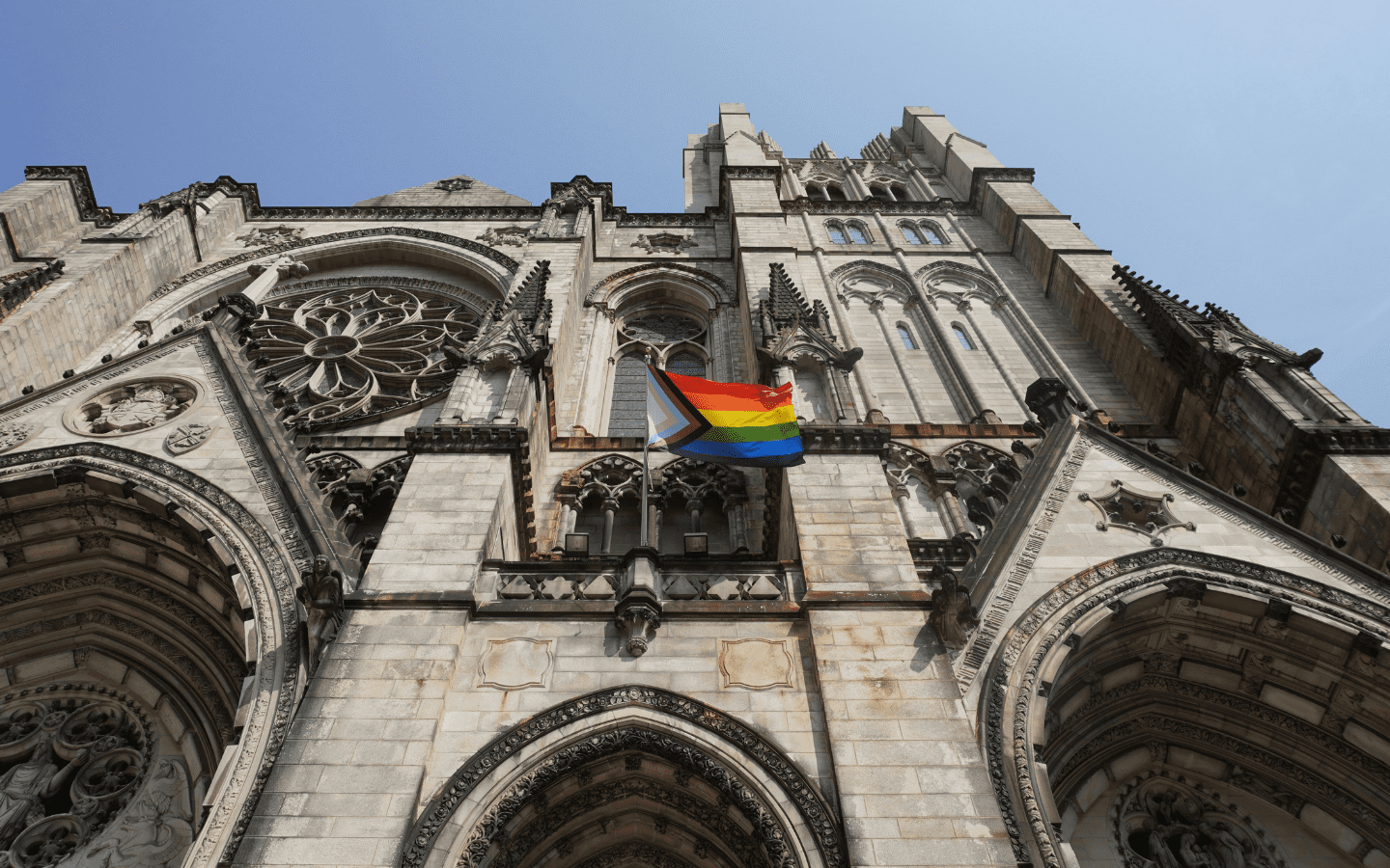 A photo of a gothic cathedral flying a Pride Flag.