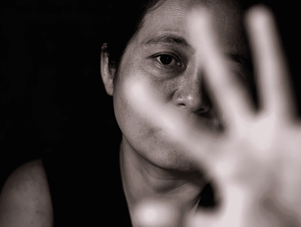 A woman holding a hand up in front of her in a gesture to stop.