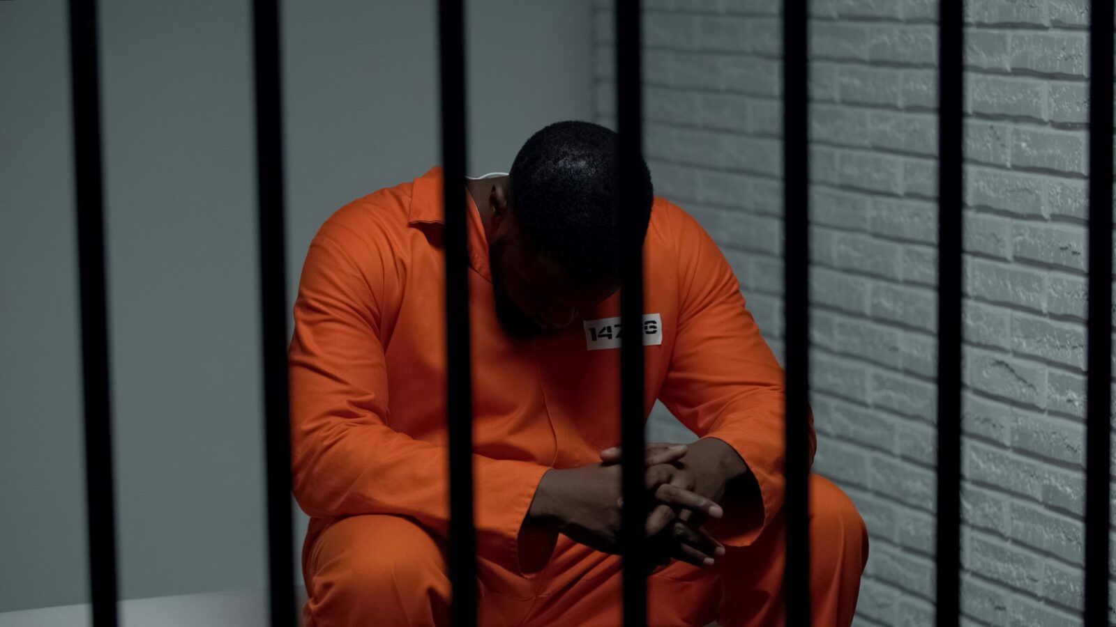 A photo of an inmate behind bars.
