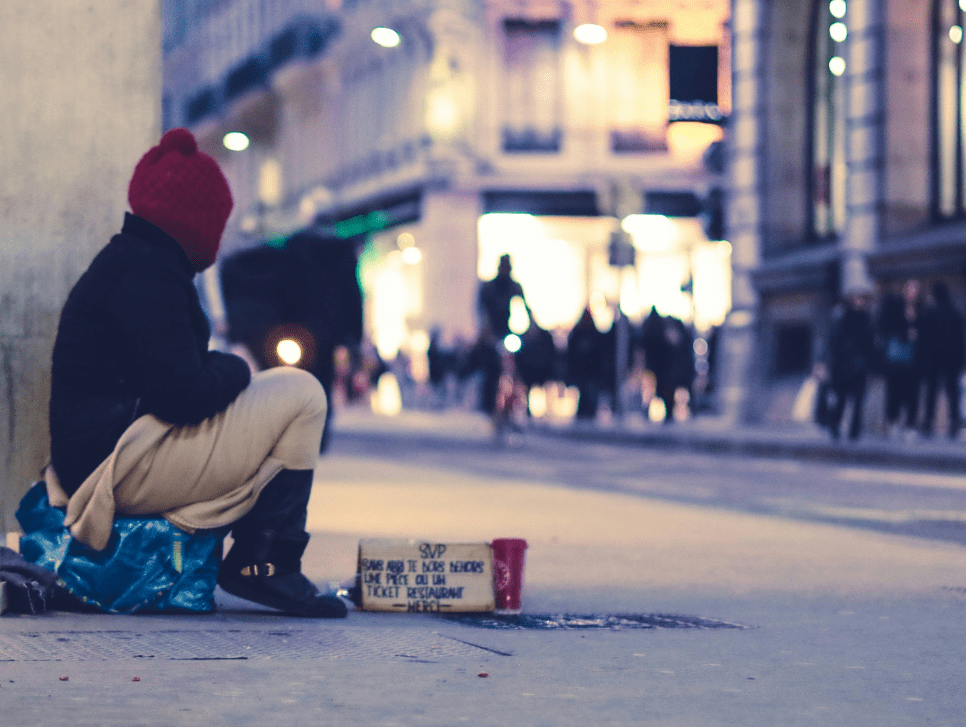 A person sitting on a street corner.|A photo of worshippers in an Anglican Church