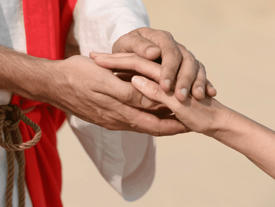 A woman with light skin holding the hand of Jesus.