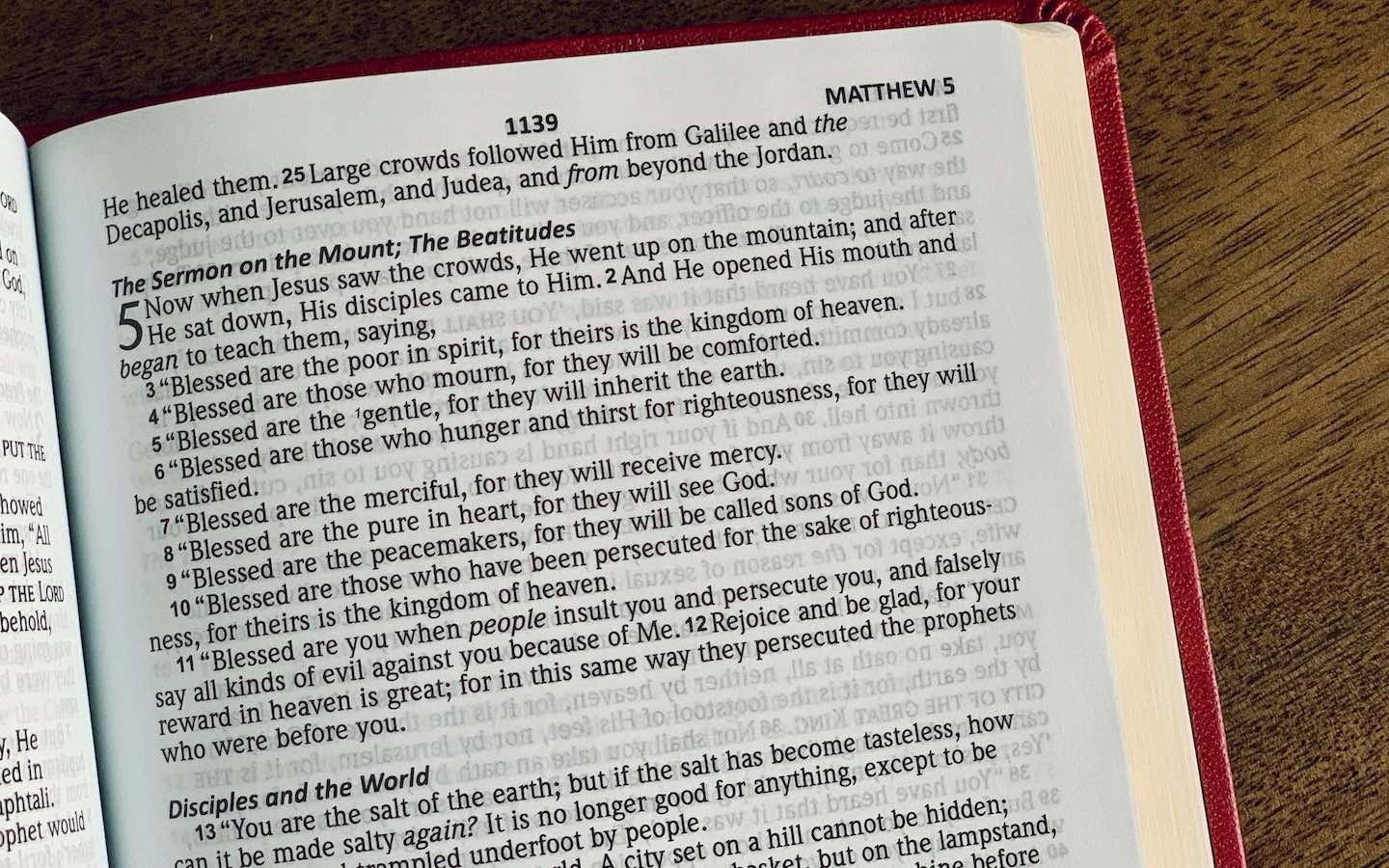 A Bible open to Matthew 5 sitting on a table.