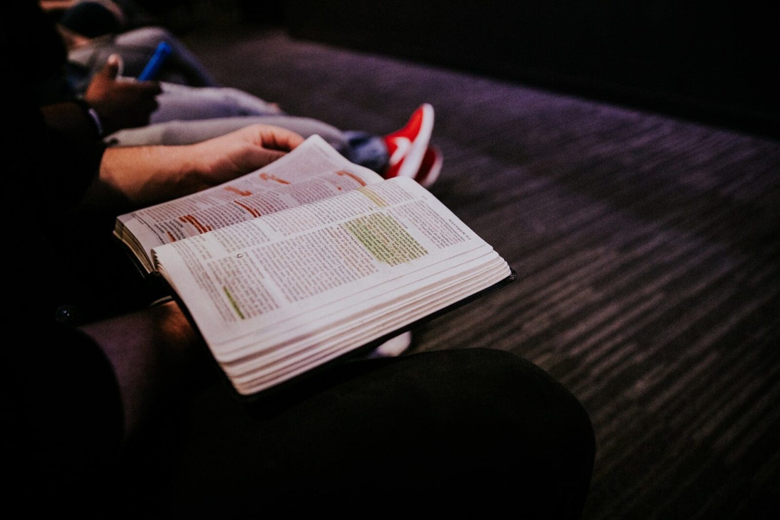 A person holding an open Bible in their hands.