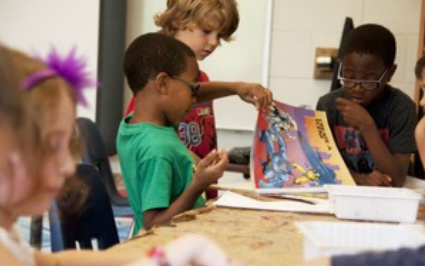 Children in a classroom looking at a book.