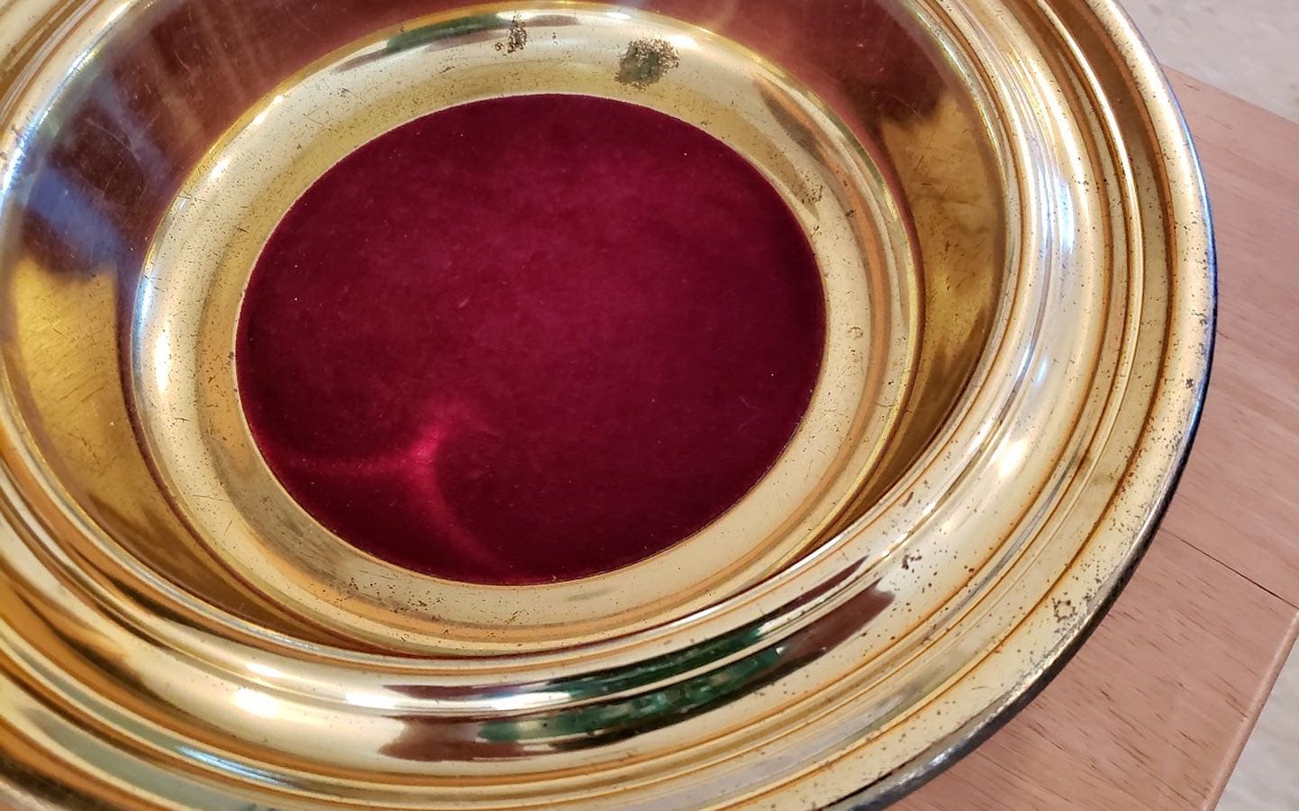 A metal church offering plate seen up close.