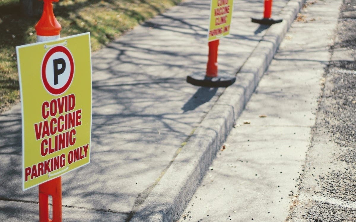 A row of signs designation parking space for COVID-19 vaccine patients.