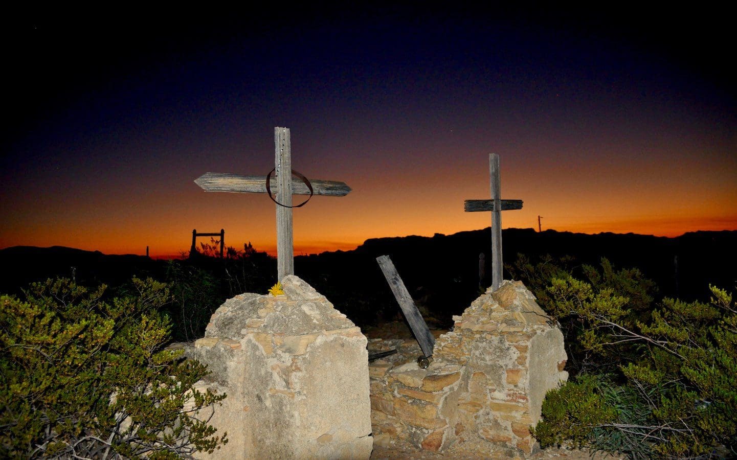 Sunrise illuminates crosses atop grave markers.
