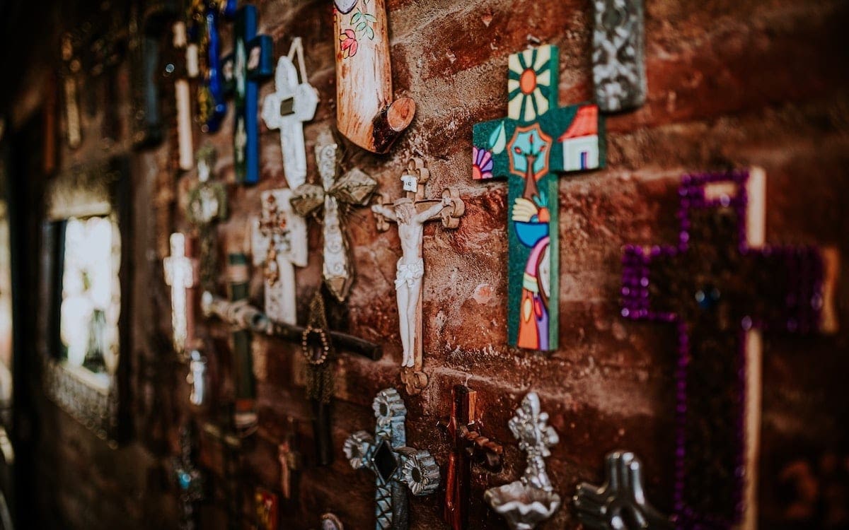 A wall of crosses with a crucifix in the center.
