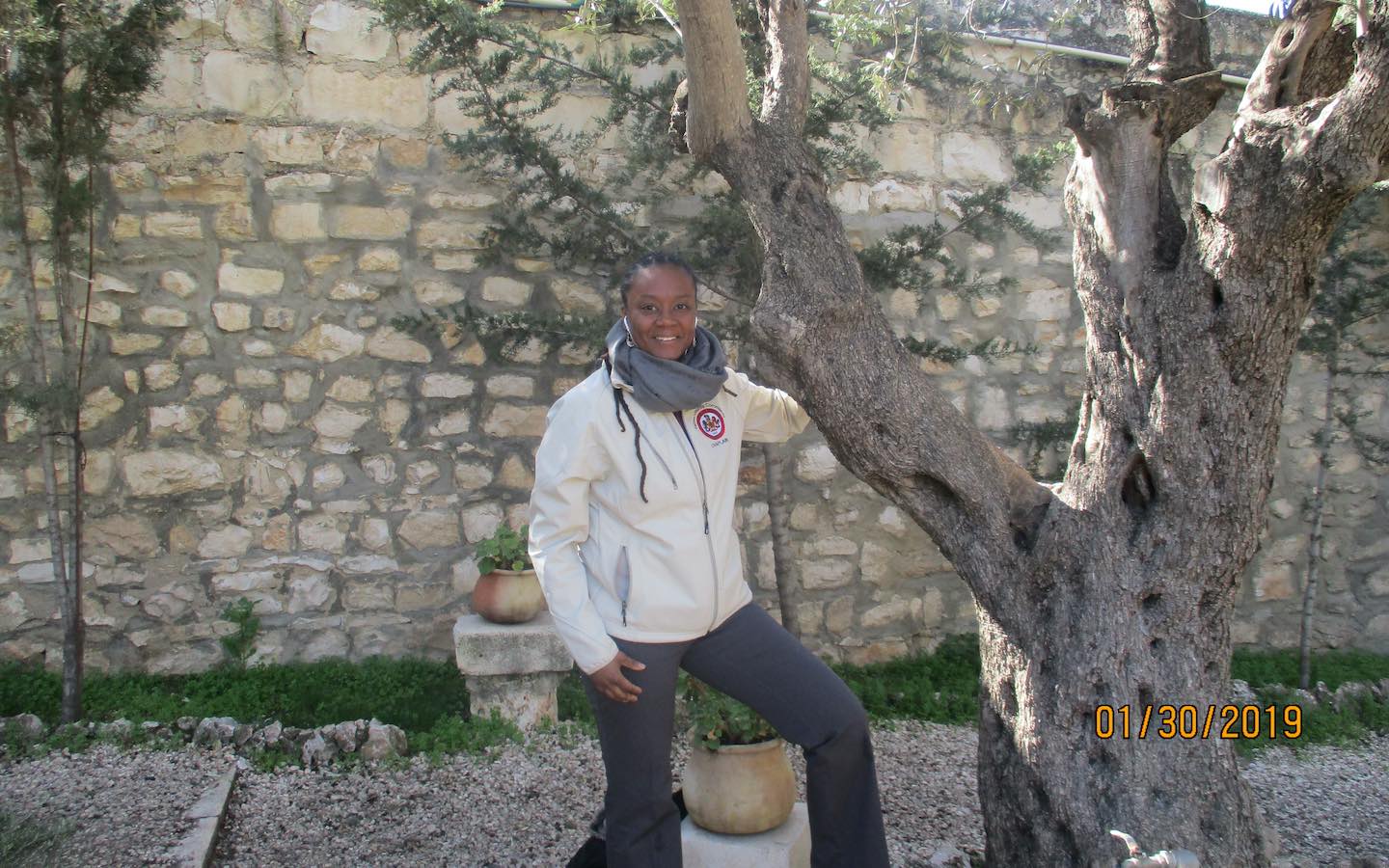 Danielle L. Bridgeforth next to a tree in the Garden of Gethsemane in Israel.