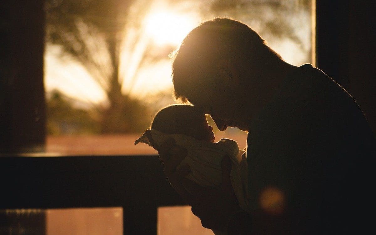 Silhouette of a father holding his young child