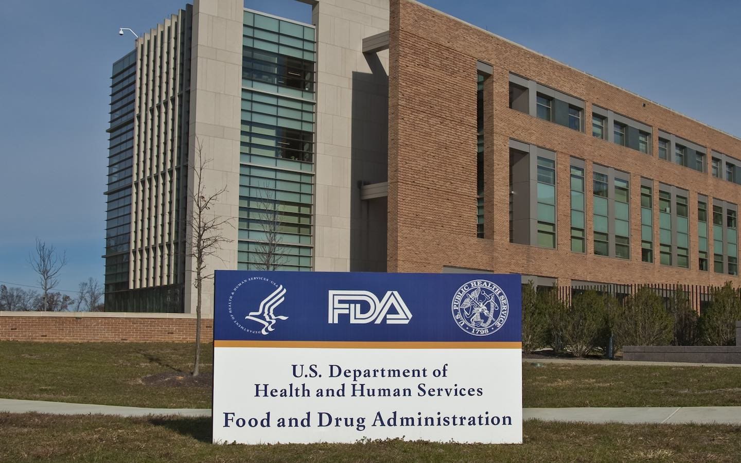 The exterior of a U.S. Food and Drug Administration building with a sign bearing the FDA logo in the foreground.