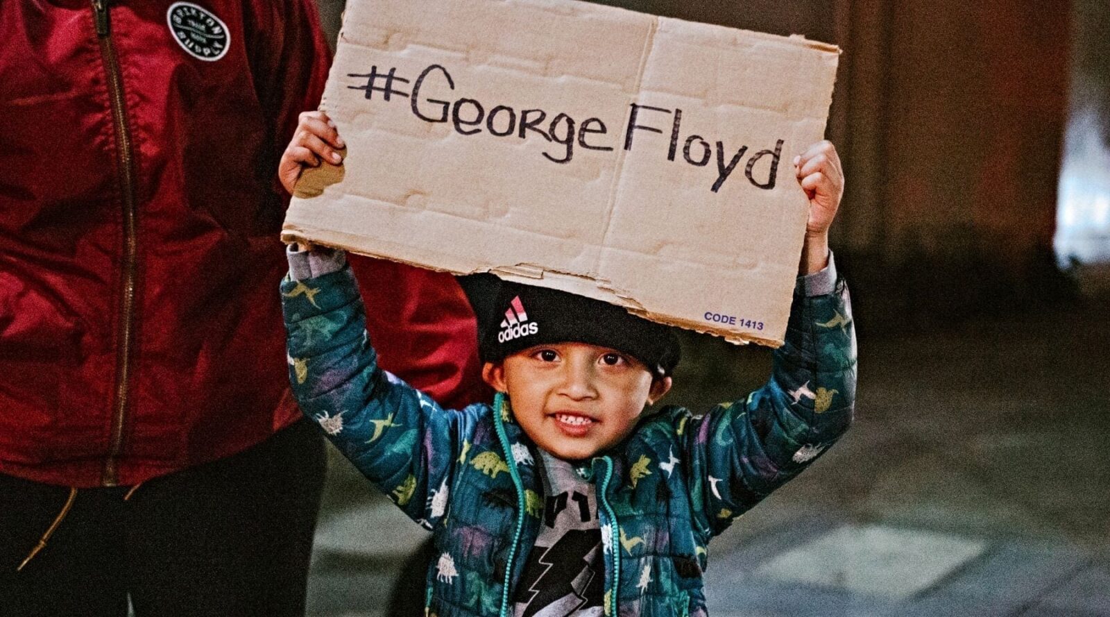 Child holding up sign saying #GeorgeFloyd