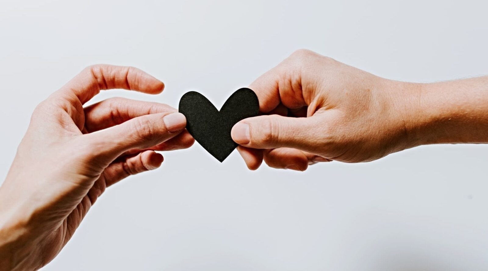 Hands holding a paper heart|
