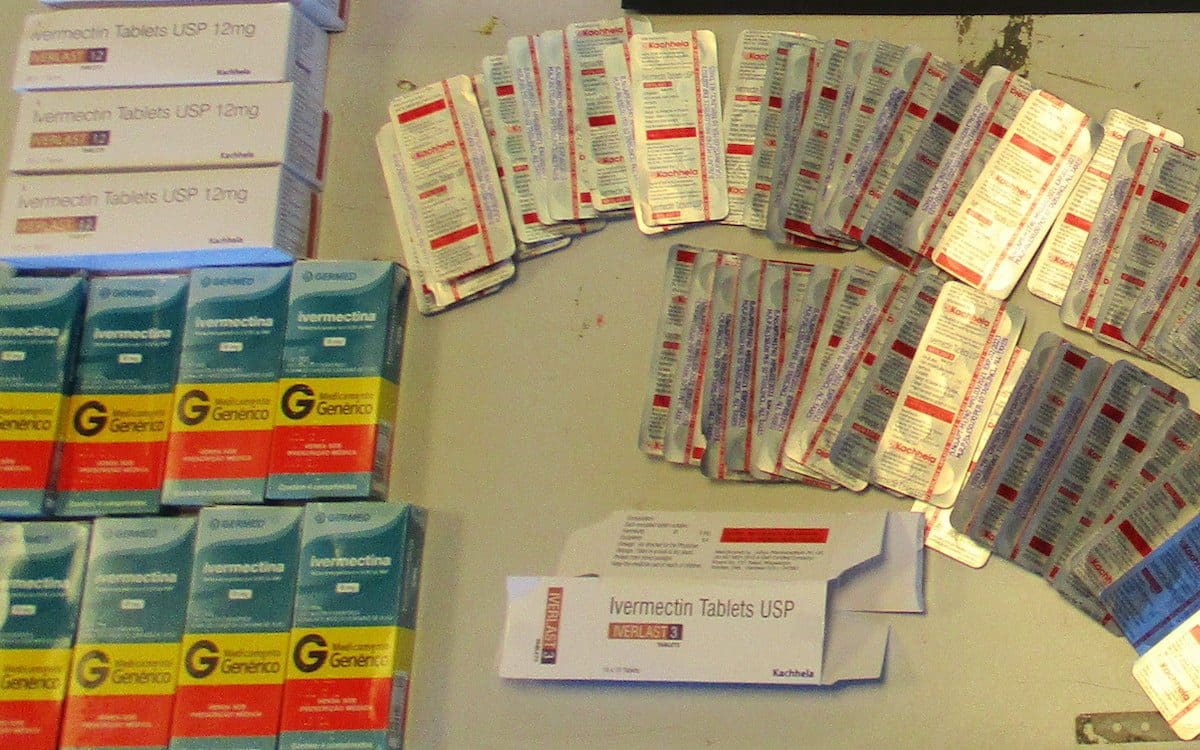 A table with several brands of Ivermectin tablets sitting on it.