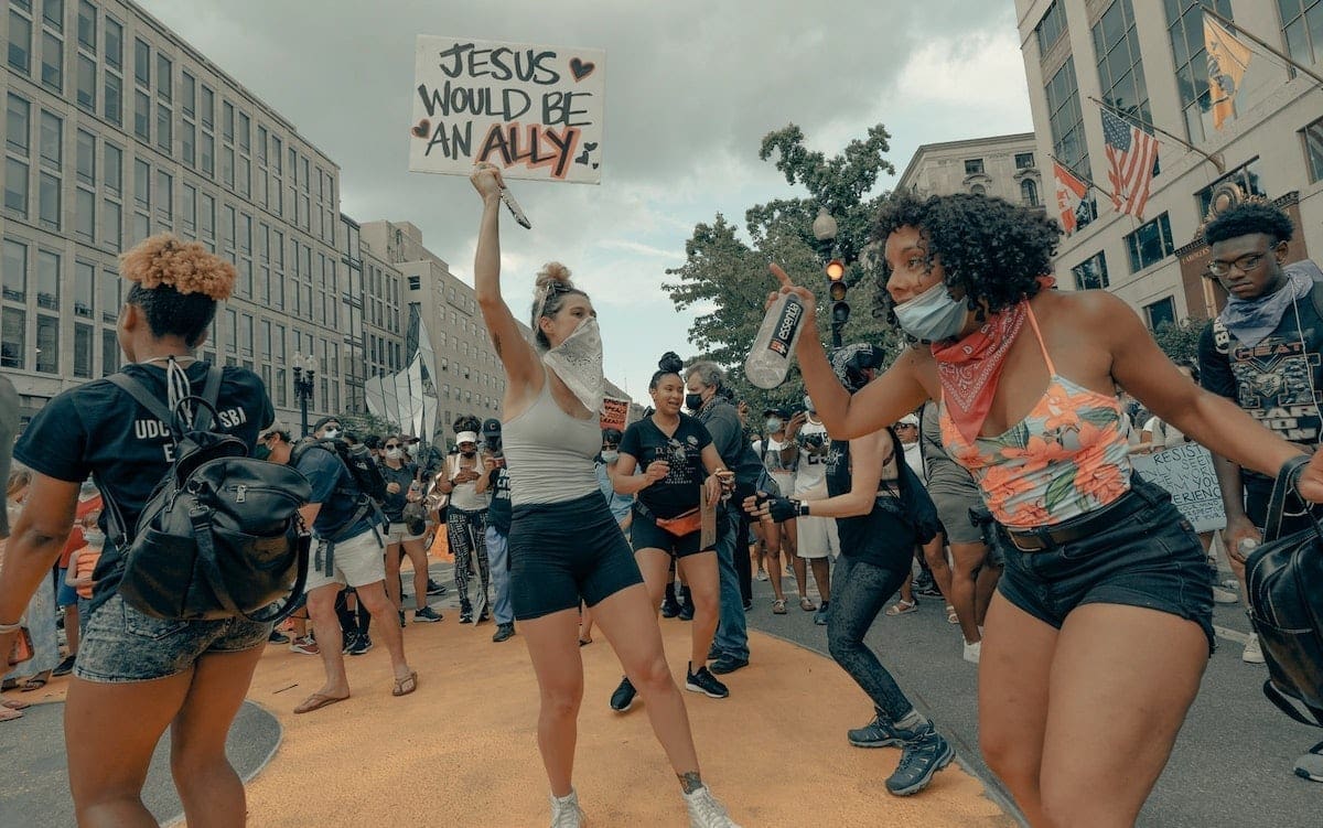 A group of people at a Black Lives Matter protest with one holding a sign that says