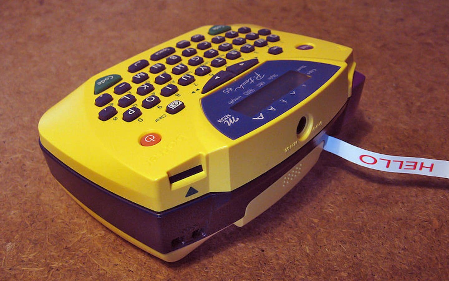 A label maker sitting on a table with a small label saying