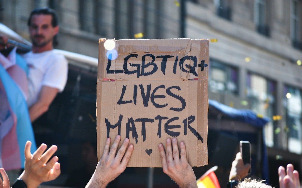 A man holding a cardboard sign that says